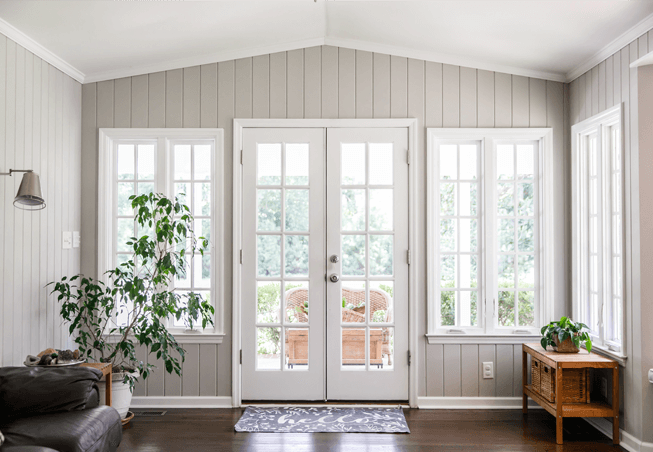 Casa cinza com janelas e portas de madeira